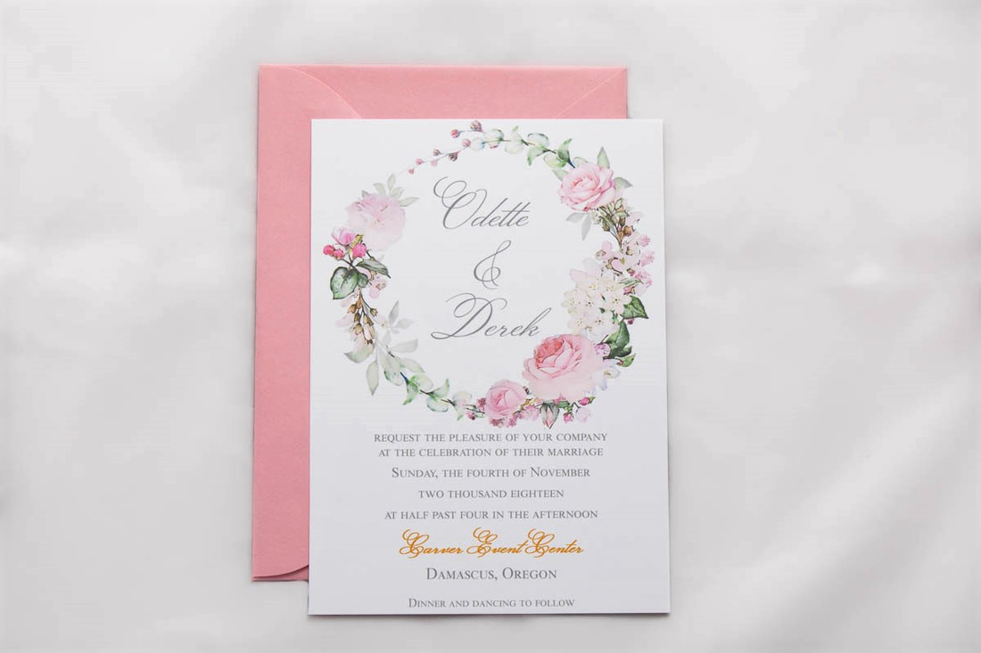 Soft pink wreath around names wedding invitation with a light pink envelope