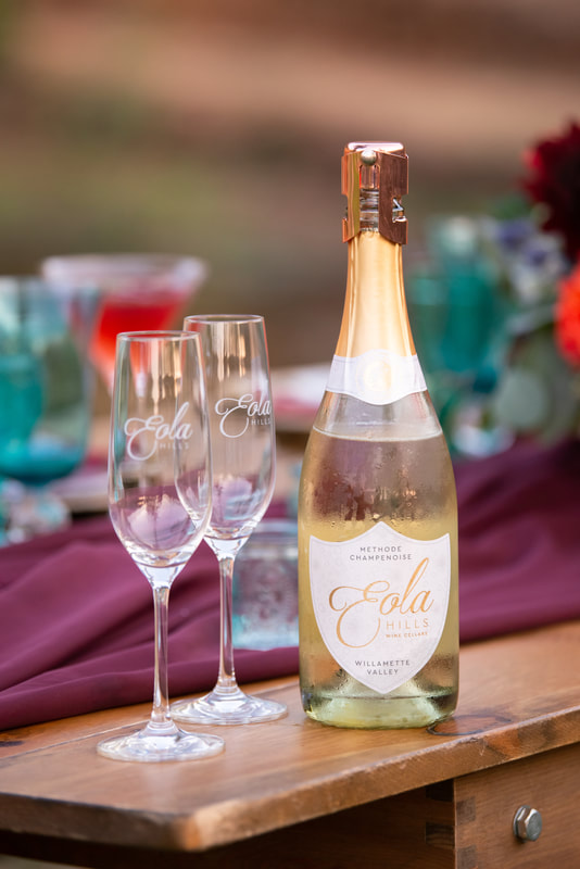 Two wine glasses with a bottle of Eola Hills Winery Methode Chamenoise